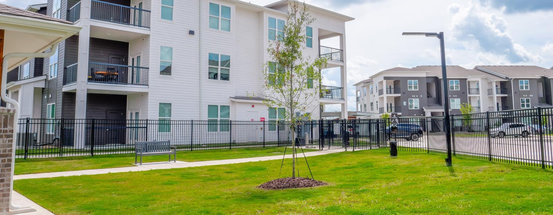a building with a fence and trees