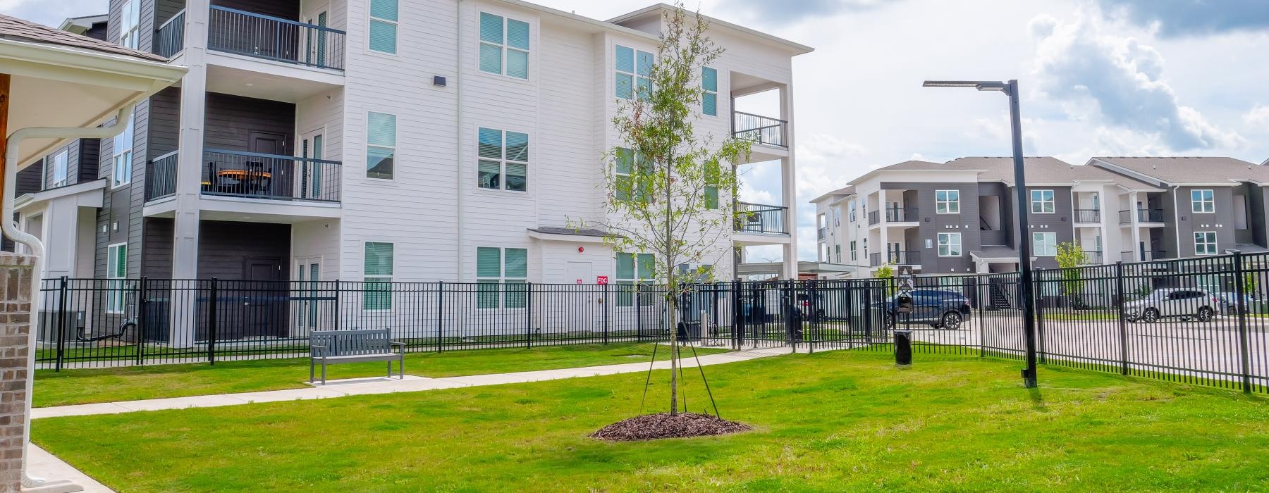 a building with a fence and trees